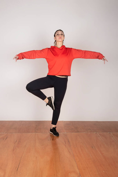 Young blonde woman dressed in sportswear doing classical dance poses - Photo, Image