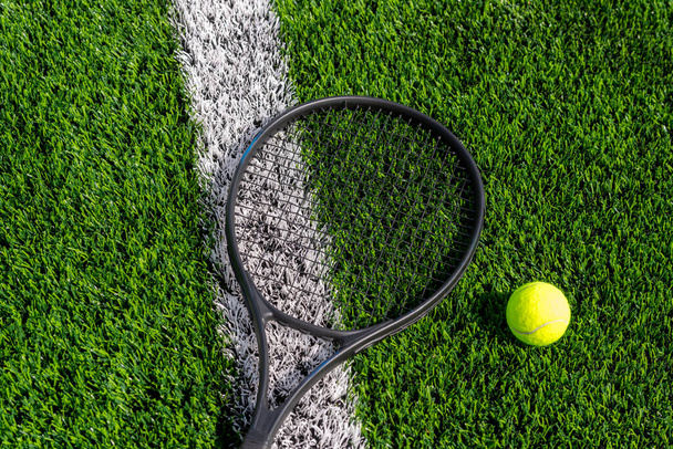 Top näkymä tennismailat ja pallo vihreää ruohoa. Horisontaalinen urheilujuliste, onnittelukortit, otsikot, verkkosivusto
 - Valokuva, kuva