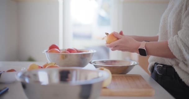 キッチンの女性はりんごケーキのリンゴを剥がします - 映像、動画