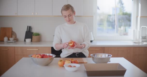 žena v kuchyni loupe jablka na jablečný koláč - Záběry, video