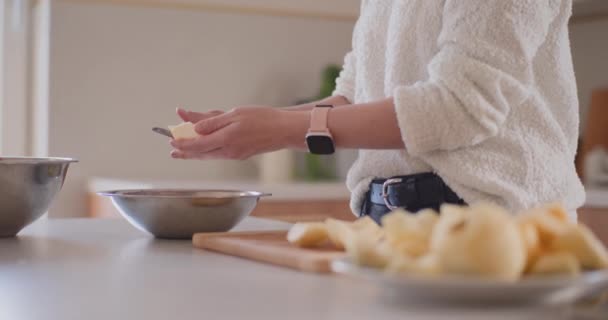 nainen keittiössä kuoria omenoita omenakakku - Materiaali, video
