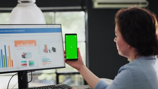 Manager holding phone with greenscreen in coworking space business headquarters, looking at mobile device with blank mockup screen. Specialist checking isolated copyspace layout. Handheld shot. - Footage, Video