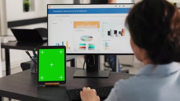 Manager watches tablet with greenscreen while she solves business operations in office, looking at device running blank mockup display. Specialist looks at chromakey software. Handheld shot. - Footage, Video