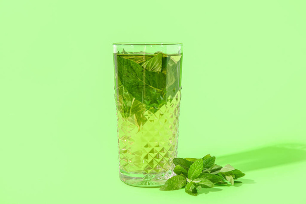 Glass of icy fresh mint tea on green background - Photo, Image
