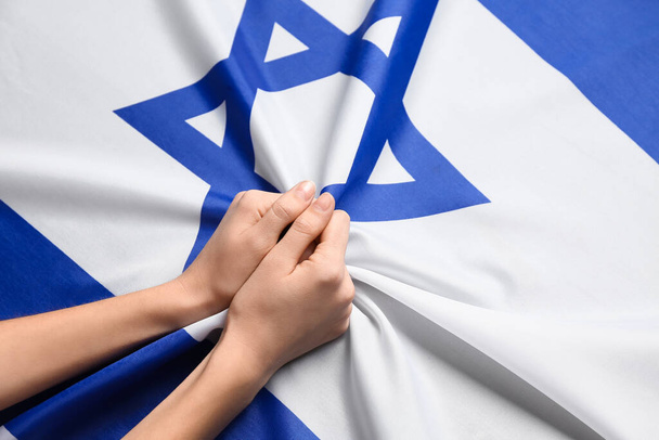 Las manos femeninas en la bandera de Israel - Foto, imagen
