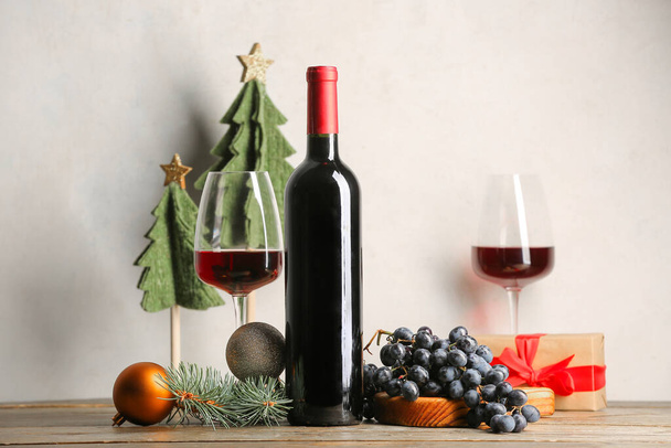 木のテーブルのクリスマスの装飾が付いているワインのびんそしてガラス - 写真・画像