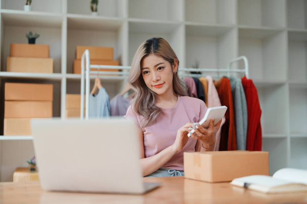 Pequenas empresas, proprietário de negócios on-line, mulher jovem está usando calculadora de lucro e verificação de inventário. - Foto, Imagem