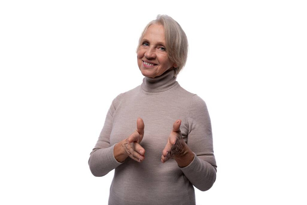 65 χρονών ικανοποιημένη Ευρωπαία ώριμη γυναίκα με κοντά μαλλιά σε λευκό φόντο. - Φωτογραφία, εικόνα
