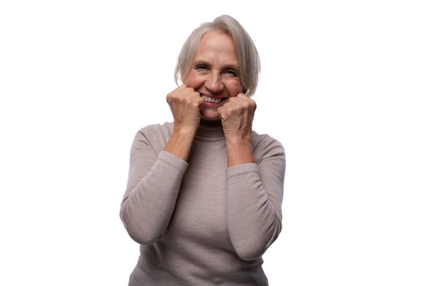 65 yaşında, Avrupalı, olgun, beyaz arka planda kısa saçlı bir kadın.. - Fotoğraf, Görsel