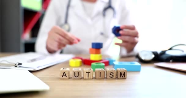 Doctor cubos de color y autismo inscripción close up. Signos de autismo en los niños y síntomas en los adultos - Metraje, vídeo