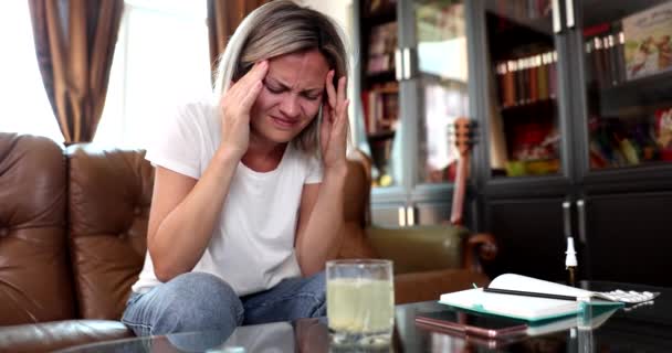 Niezdrowa kobieta z bolesnym wyrazem twarzy czuje się źle i cierpi na migrenę. Kobieta zażywająca tabletki przeciwbólowe, aby złagodzić ból - Materiał filmowy, wideo