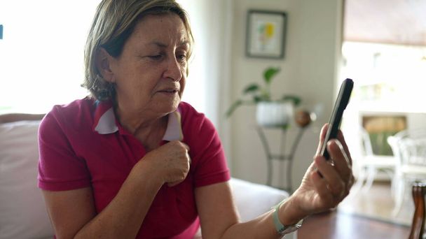 Ältere Frau im Videochat mit Familie von zu Hause aus, Oma in Verbindung mit Geliebten per Smartphone-Videoanruf - Foto, Bild
