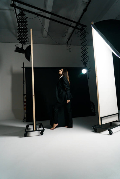 Stylová dívka pózující v černém obleku a bílé košili v profesionálním fotostudiu. Koncept módního natáčení - Fotografie, Obrázek