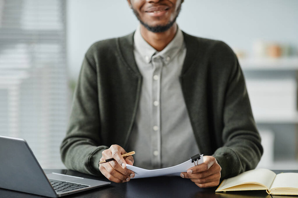 Gros plan du jeune homme noir tenant un CV avec des lettres de motivation dans l'entretien d'embauche, espace de copie - Photo, image
