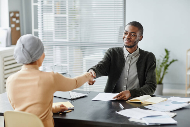 Retrato del joven hombre negro estrechando la mano con el gerente de recursos humanos femenino después de una exitosa entrevista de trabajo en la oficina, espacio para copiar - Foto, Imagen