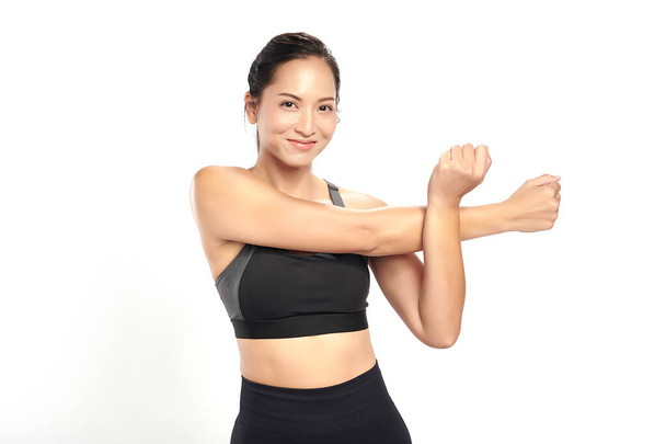 eine asiatische Frau trainiert im Sportanzug mit weißem Hintergrund, - Foto, Bild