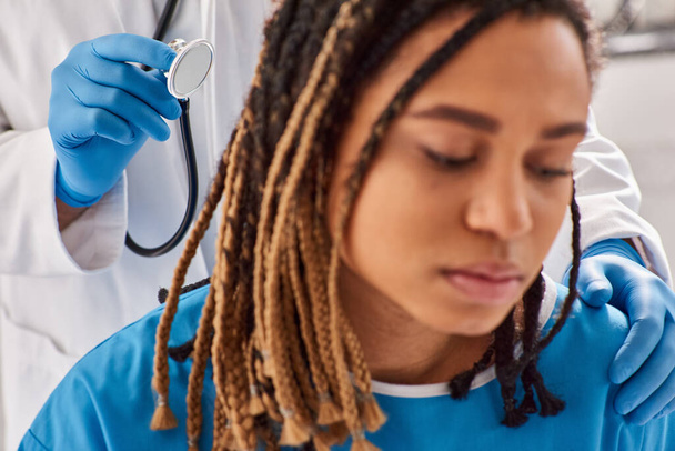 Fokus auf Arzt überprüft Atem seines verschwommenen afrikanisch-amerikanischen Patienten auf Krankenhausstation, Gesundheitswesen - Foto, Bild
