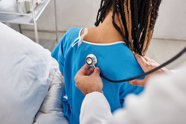 Hintli doktorun hastane koğuşundaki Afrikalı Amerikalı hastasının nefesini kontrol edişi. - Fotoğraf, Görsel