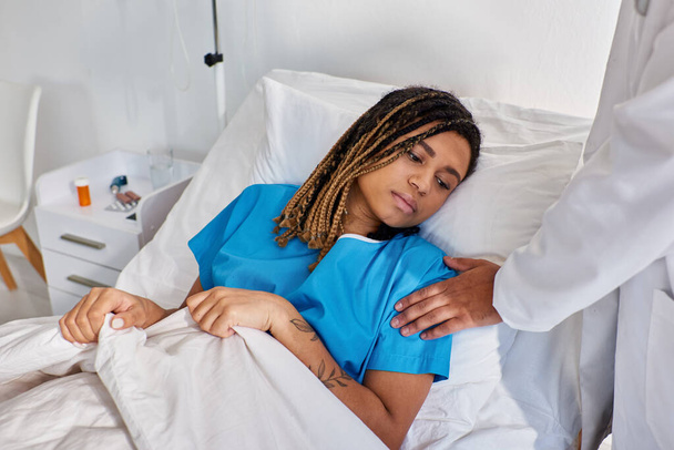 vista recortada del médico indio consolando a su paciente afro-americano enfermo, salud - Foto, imagen