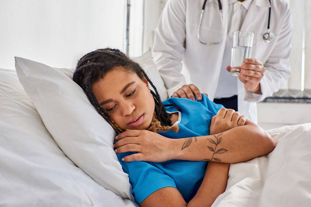 vista ritagliata del medico indiano confortando il suo malato triste paziente afroamericano donna, assistenza sanitaria - Foto, immagini