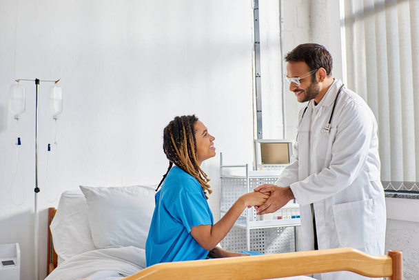 hilpeä intialainen lääkäri lasit kättelee hänen iloinen afrikkalainen amerikkalainen potilas, terveydenhuolto - Valokuva, kuva