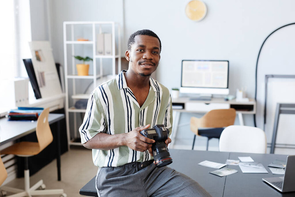 Мінімальний портрет чорного фотографа, який дивиться на камеру в студії, копіює простір - Фото, зображення