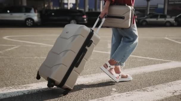 African American lady walking along the parking outside and holding luggage. Cropped. People, lifestyle, travel concept. Slow motion - Footage, Video