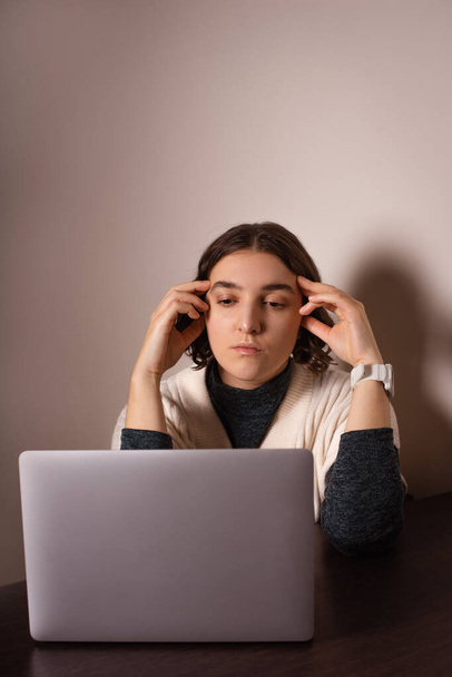 Женщина страдает головной болью из-за крайнего срока, работает в Интернете, ищет решение проблемы - Фото, изображение