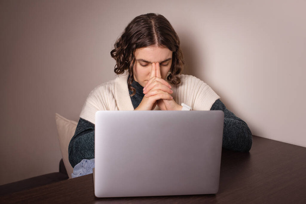 Беспокойная женщина, сидящая с ноутбуком, чувствует страх. женщина напряжена, принимая трудное решение - Фото, изображение