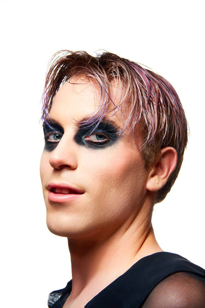 Portrait of young smiling man, guy with pink hair, smoky eyes makeup looking at camera isolated on white studio background. Concept of male makeup, fashion, lgbtq community, self-identity, acceptance - Фото, изображение
