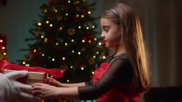 Nuori tyttö vastaanottaa lahja joulupukilta . - Materiaali, video