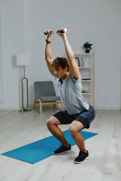 home man életmód sport izom fizikai abs apartman súlyzók képzés beltéri testmozgás mat ház egészség egészséges szoba nappali tevékenység nyújtás gyakorlása szürke - Fotó, kép