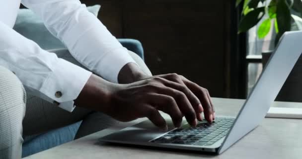 Een geconcentreerde zwarte man is verdiept in het werk en typt ijverig op laptop. Zijn onwrikbare focus en vastberadenheid schitteren door terwijl hij taken met precisie en toewijding aanpakt. - Video