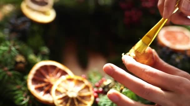 Il decoratore dipinge una cipolla durante una ghirlanda Di Capodanno con vernice d'oro. Filmati 4k di alta qualità - Filmati, video