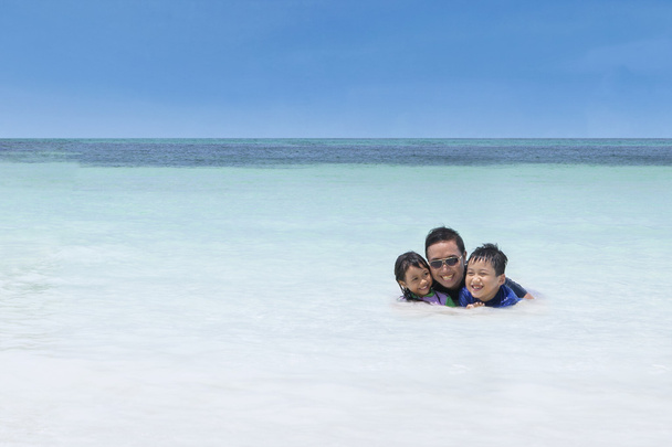 Man swimming with his children on beach - Foto, Imagem
