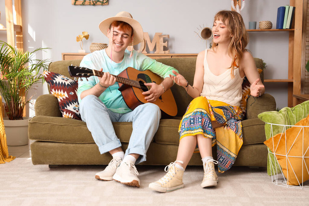 Un par de hippies tocando la guitarra en casa - Foto, imagen