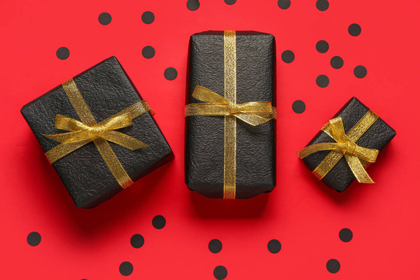 Подарочные коробки и конфетти на красном фоне. Чёрная пятница - Фото, изображение