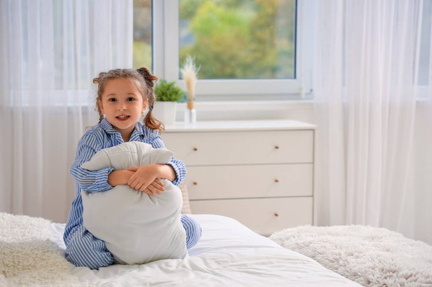 Χαριτωμένο κοριτσάκι με μαξιλάρι στην κρεβατοκάμαρα - Φωτογραφία, εικόνα