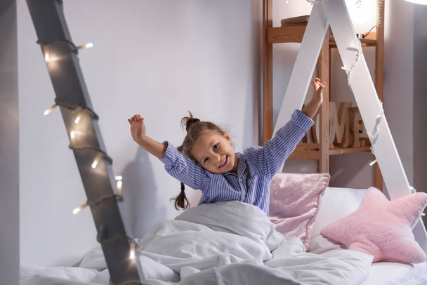 Schattig klein meisje in slaapkamer 's nachts - Foto, afbeelding