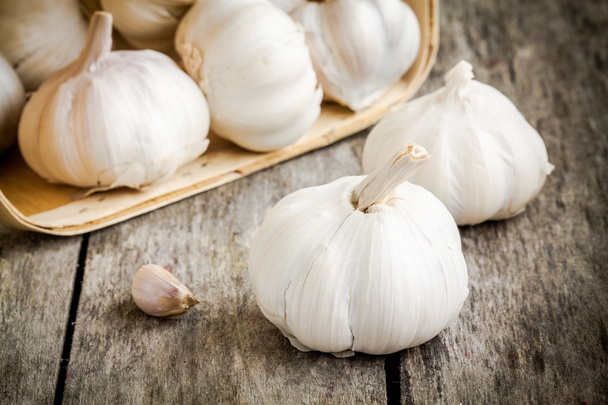 organic garlic bulbs on a wooden background - Фото, изображение