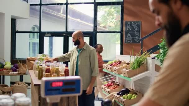 チェックアウトスキャンおよび重み付け商品のマーチャントは,ローカルゼロエコストアで頻繁に顧客に販売します. 若い大人が野菜を大規模に置き,地元で栽培された農産物を販売. - 映像、動画