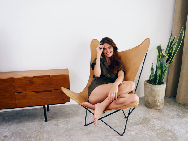 Mulher sentada em uma cadeira em casa belo sorriso, diversão e relaxamento, moderno estilo de vida elegante interior scandia, espaço de cópia. Foto de alta qualidade - Foto, Imagem