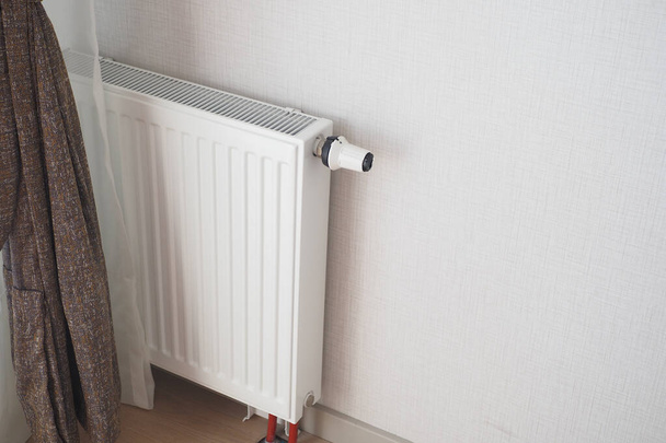 White radiator on grey white wall. apartment heating installation system, . - Photo, Image