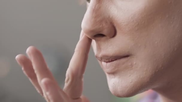 Gros plan de jeune homme queer caucasien appliquant correcteur avec des tampons de doigt tout en faisant du maquillage dans les coulisses de la salle - Séquence, vidéo