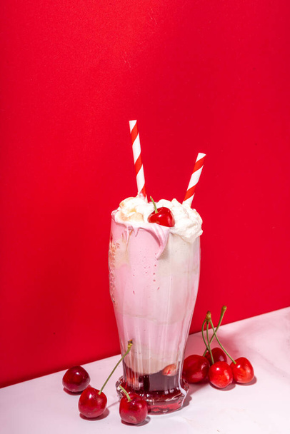 Сладкий домашний вишневый коктейль со взбитыми сливками, мороженым, холодной колой, свежими вишнями и сиропом - Фото, изображение
