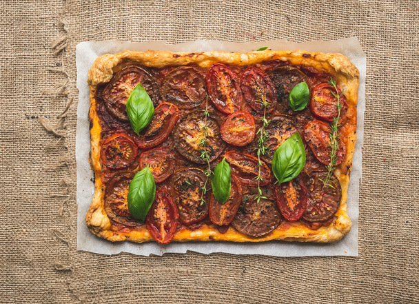 Rustic tomato autumn pie on a silver tray over a sackcloth surfa - Photo, Image
