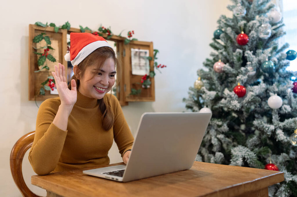 Celebrare il Natale, nuova stagione anno, giovane donna saluto in videochiamata durante la distanza sociale. - Foto, immagini