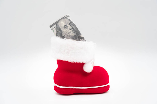 Dollars avec botte du Père Noël sur fond blanc. Joyeux Noël et Bonne Année Concept. Fond de Noël. espace de copie. - Photo, image