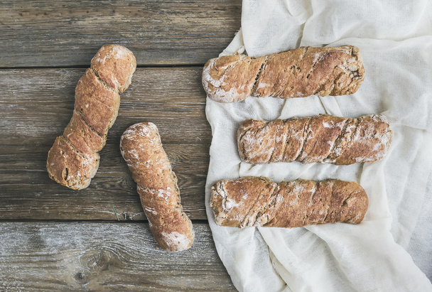Freshly baked rustic  village bread (baguettes) set on rough woo - Foto, afbeelding