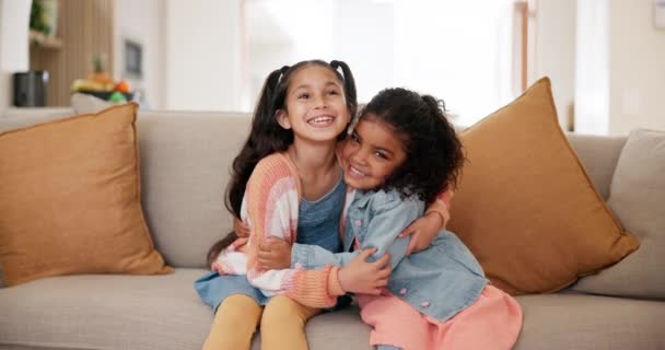 Happy, děti nebo tvář s objetím sester na pohovce, péče nebo podpora společně v obývacím pokoji. Děti, objetí a sourozenci pro úsměv portrét ve vztahu sblížení, relaxační víkend a wellness doma. - Záběry, video